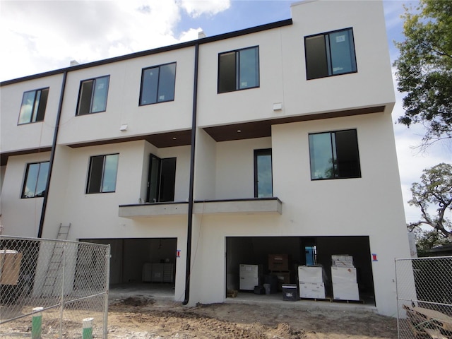 back of property with fence and stucco siding