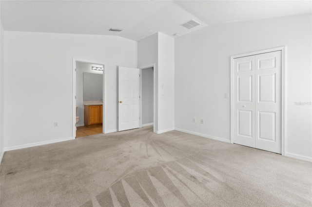 25830 Crippen Dr, Land O Lakes, FL 34639 - unfurnished bedroom featuring vaulted ceiling, light colored carpet, connected bathroom, and a closet