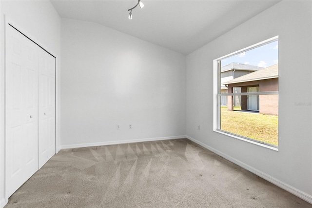 25830 Crippen Dr, Land O Lakes, FL 34639 - unfurnished bedroom with lofted ceiling, carpet, multiple windows, a closet, and track lighting
