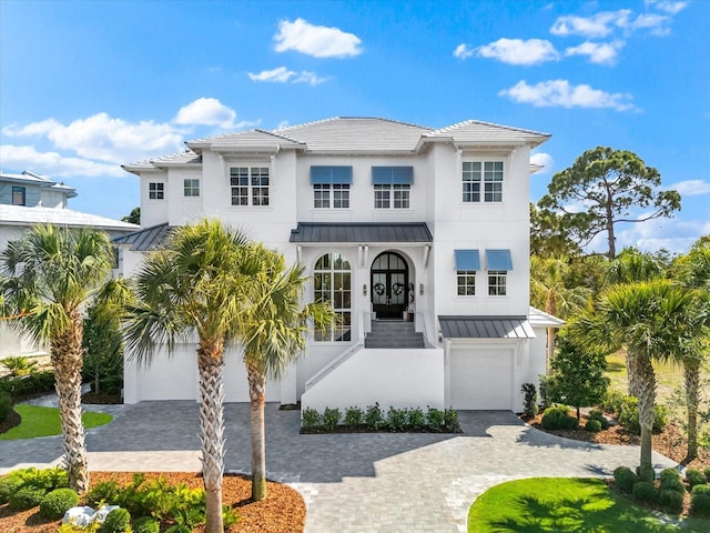 885 Seaview Cir Unit 20, Crystal Beach, FL 34681 - view of front of property featuring a garage, a standing seam roof, decorative driveway, stucco siding, and metal roof