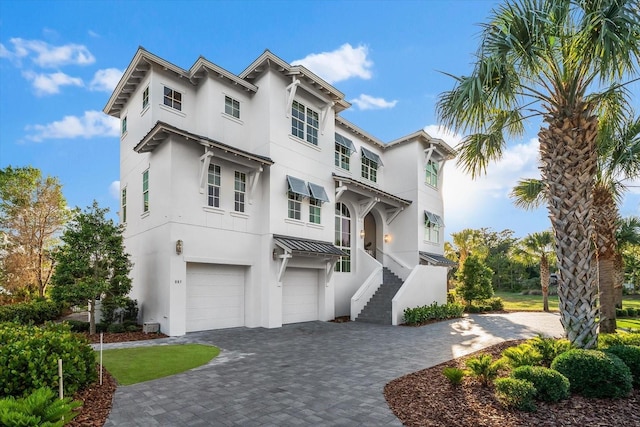 885 Seaview Cir Unit 20, Crystal Beach, FL 34681 - view of front of property with stucco siding, decorative driveway, an attached garage, and a standing seam roof