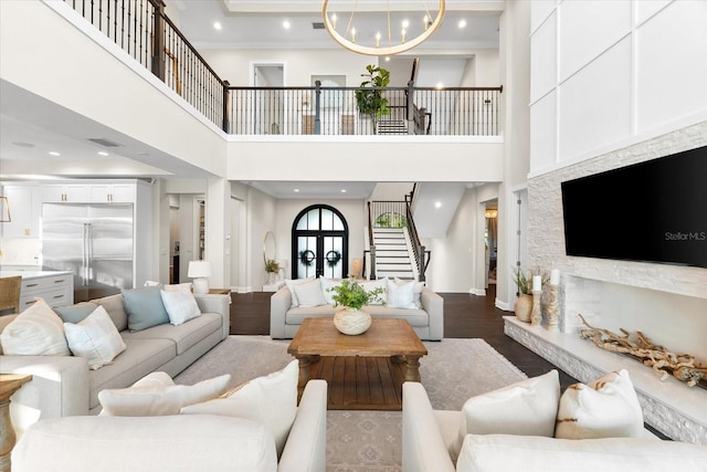 885 Seaview Cir Unit 20, Crystal Beach, FL 34681 - living room featuring stairway, crown molding, wood finished floors, a chandelier, and a towering ceiling