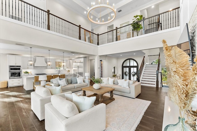 885 Seaview Cir Unit 20, Crystal Beach, FL 34681 - living room featuring a high ceiling, dark wood-style flooring, a chandelier, ornamental molding, and stairs