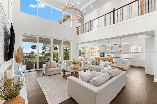 885 Seaview Cir Unit 20, Crystal Beach, FL 34681 - living area featuring a towering ceiling, a chandelier, dark wood-style flooring, ornamental molding, and recessed lighting