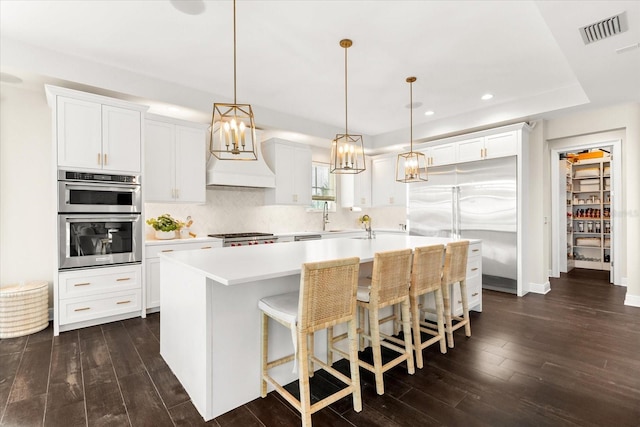 885 Seaview Cir Unit 20, Crystal Beach, FL 34681 - kitchen featuring appliances with stainless steel finishes, light countertops, dark wood-type flooring, a kitchen island with sink, and recessed lighting