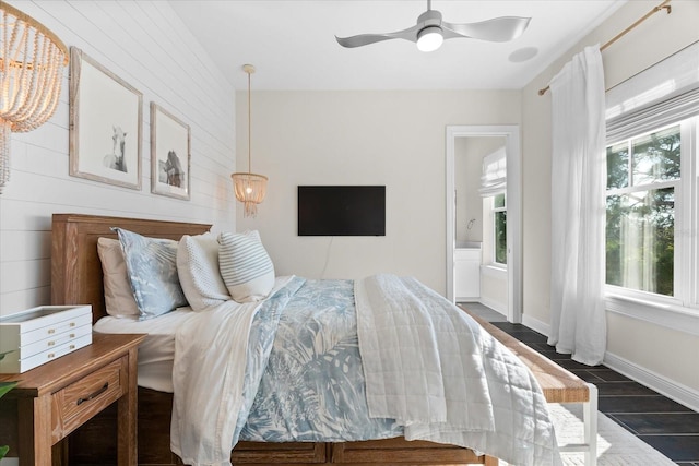 885 Seaview Cir Unit 20, Crystal Beach, FL 34681 - bedroom featuring dark wood-style flooring, connected bathroom, wooden walls, ceiling fan, and baseboards
