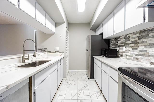 kitchen featuring backsplash, appliances with stainless steel finishes, a sink, white cabinets, and marble finish floor
