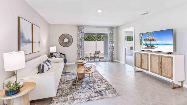 living area featuring light tile patterned flooring, baseboards, and visible vents