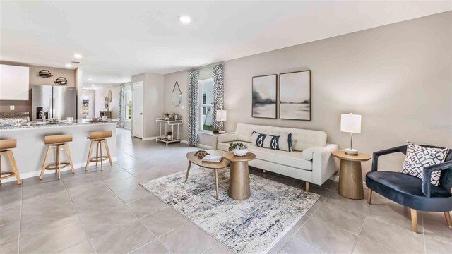 living room featuring recessed lighting, baseboards, and light tile patterned floors