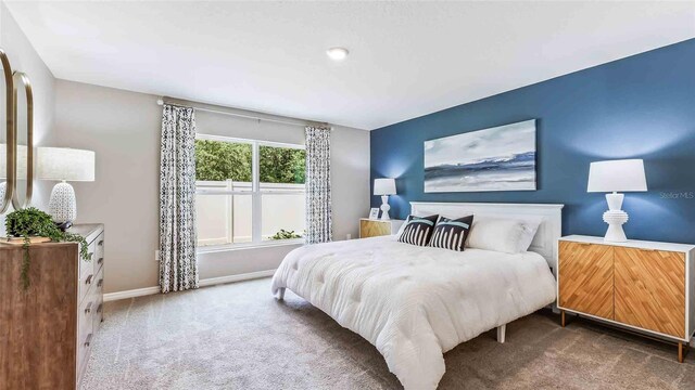 bedroom with baseboards and carpet