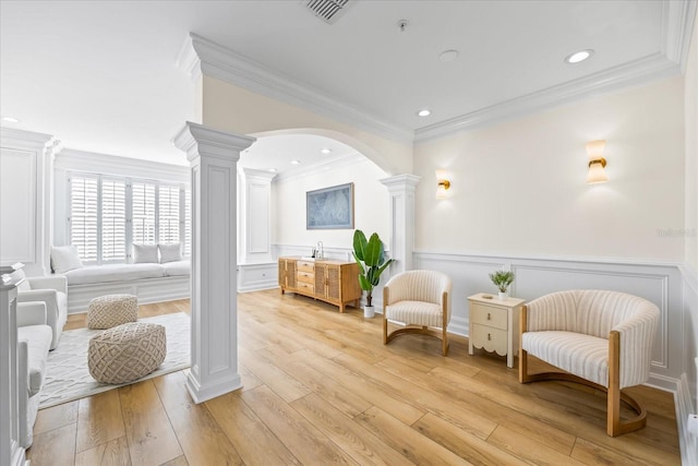 1476 Harbour Walk Rd, Tampa, FL 33602 - living area with ornate columns, crown molding, light wood-style flooring, arched walkways, and wainscoting