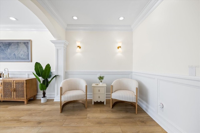 1476 Harbour Walk Rd, Tampa, FL 33602 - living area with decorative columns, light wood finished floors, a decorative wall, crown molding, and wainscoting