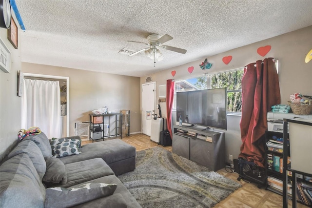 living area with a textured ceiling, ceiling fan, and visible vents