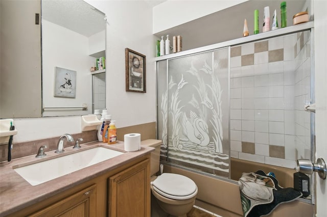 bathroom featuring vanity, toilet, and shower / bath combination with glass door