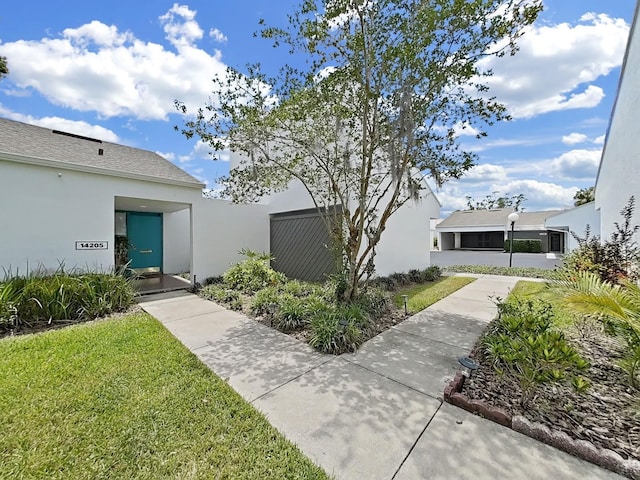 exterior space with stucco siding and a front yard