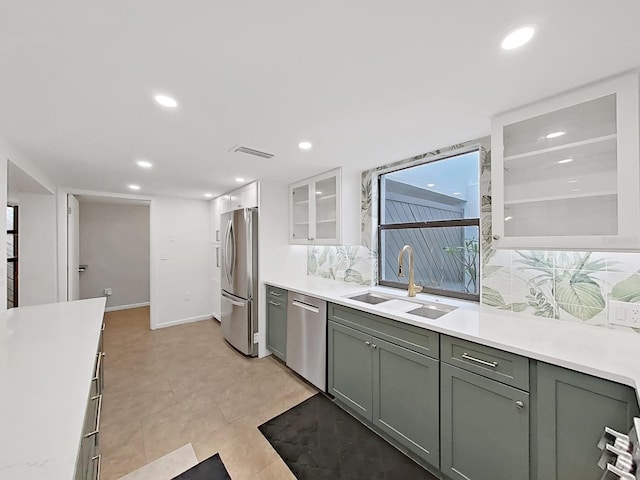 kitchen with appliances with stainless steel finishes, a sink, light countertops, recessed lighting, and white cabinetry