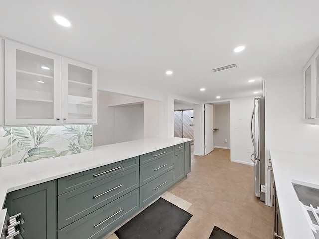 kitchen featuring light countertops, freestanding refrigerator, recessed lighting, and visible vents