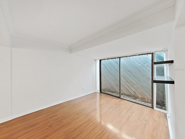 empty room with baseboards and wood finished floors