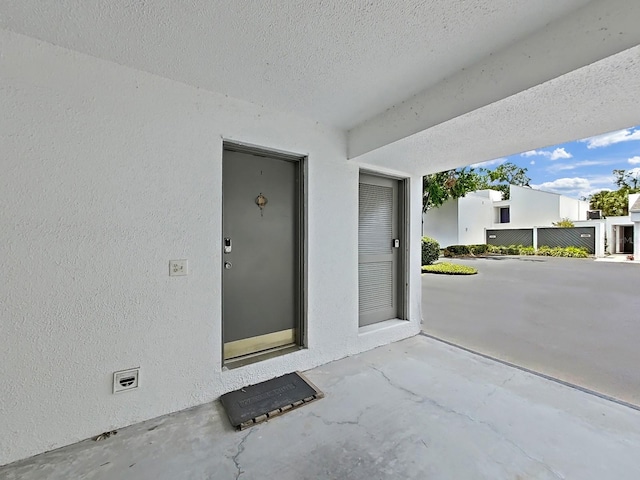 doorway to property featuring a patio area and stucco siding