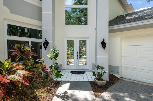 entrance to property featuring a garage, stucco siding, french doors, and a shingled roof
