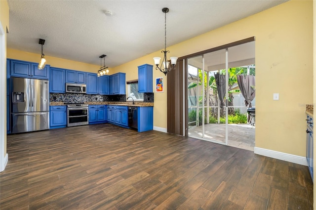 kitchen featuring backsplash, stainless steel appliances, blue cabinetry, and baseboards