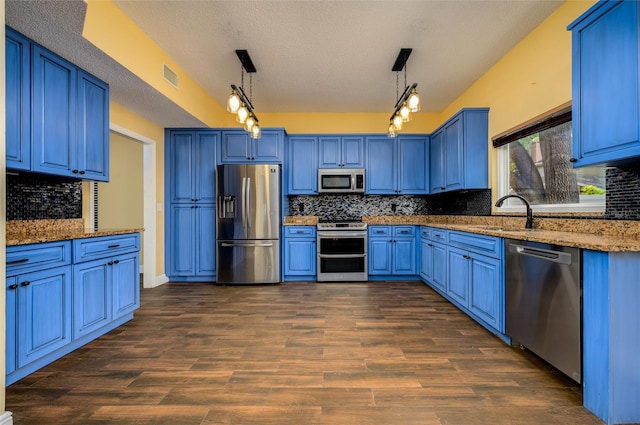 kitchen featuring appliances with stainless steel finishes, blue cabinets, a textured ceiling, and visible vents