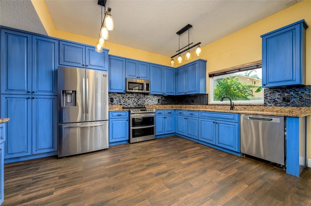 kitchen with stainless steel appliances, blue cabinetry, rail lighting, and a textured ceiling