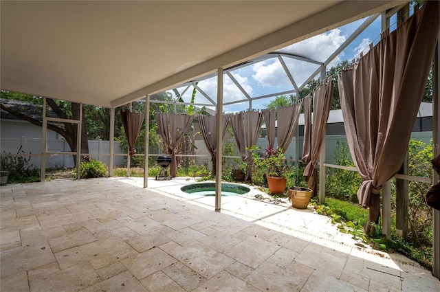 view of patio / terrace featuring a lanai, a jacuzzi, and a fenced backyard