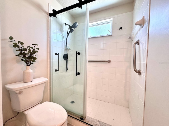 bathroom featuring toilet and a shower stall