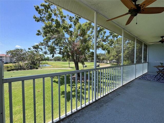 balcony with a water view, a ceiling fan, and golf course view