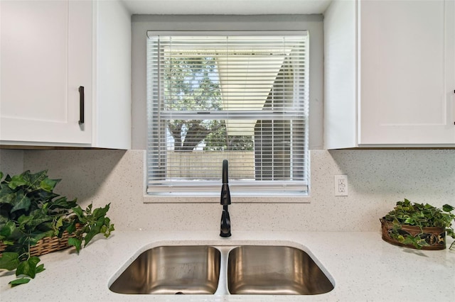 4940 Rosedale Ln, Holiday, FL 34690 - interior details featuring a sink, white cabinetry, and tasteful backsplash