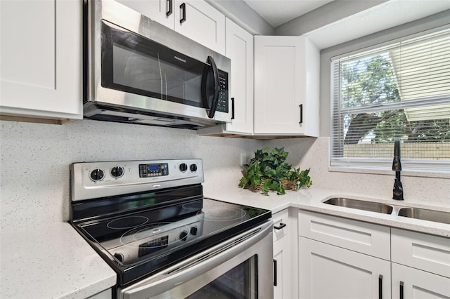 4940 Rosedale Ln, Holiday, FL 34690 - kitchen featuring appliances with stainless steel finishes, tasteful backsplash, a sink, light stone counters, and white cabinetry