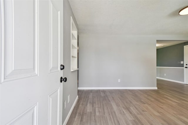 4940 Rosedale Ln, Holiday, FL 34690 - foyer entrance featuring baseboards, a textured ceiling, and wood finished floors