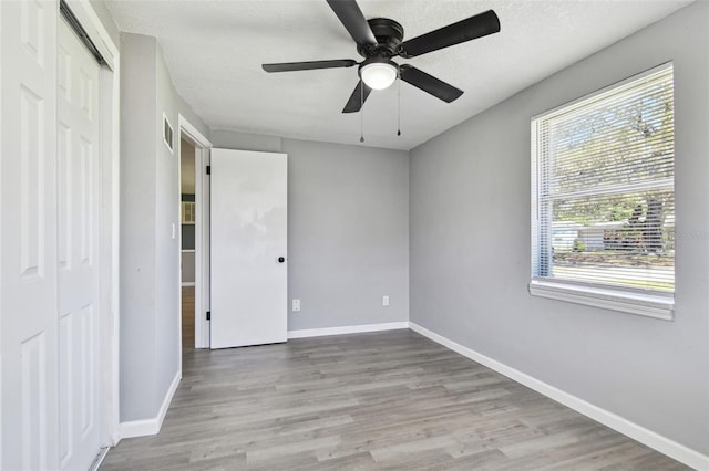 4940 Rosedale Ln, Holiday, FL 34690 - unfurnished bedroom featuring baseboards, visible vents, wood finished floors, and a closet