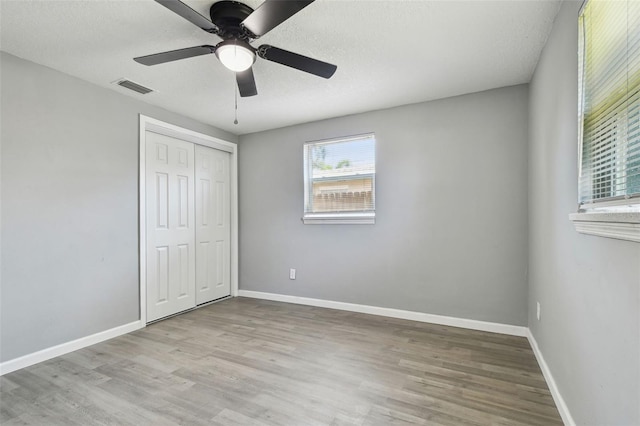 4940 Rosedale Ln, Holiday, FL 34690 - unfurnished bedroom with visible vents, baseboards, wood finished floors, and a closet