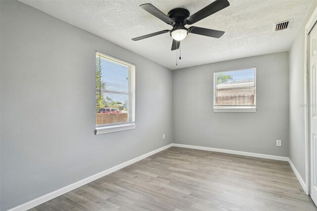 4940 Rosedale Ln, Holiday, FL 34690 - unfurnished room with visible vents, wood finished floors, baseboards, a textured ceiling, and a ceiling fan