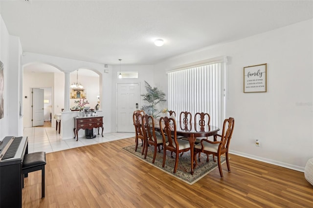 19129 Lake Audubon Dr, Tampa, FL 33647 - dining space with arched walkways, baseboards, decorative columns, and light wood finished floors