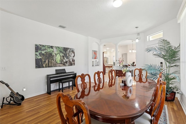 19129 Lake Audubon Dr, Tampa, FL 33647 - dining space featuring visible vents, arched walkways, light wood-type flooring, baseboards, and ornate columns