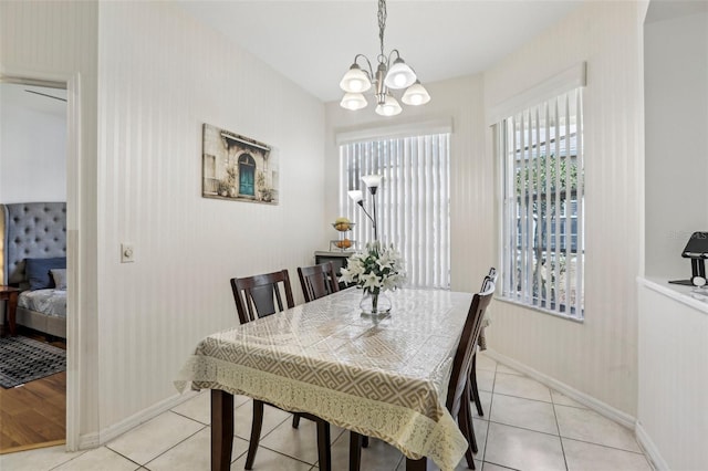19129 Lake Audubon Dr, Tampa, FL 33647 - dining area with light tile patterned floors, baseboards, and an inviting chandelier