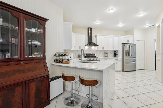19129 Lake Audubon Dr, Tampa, FL 33647 - kitchen with light tile patterned floors, stainless steel appliances, a peninsula, and wall chimney exhaust hood