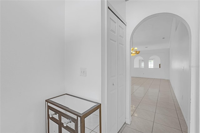 4617 Horseshoe Pick Ln, Valrico, FL 33594 - hallway featuring arched walkways, light tile patterned flooring, and a chandelier