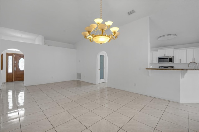 4617 Horseshoe Pick Ln, Valrico, FL 33594 - unfurnished living room with arched walkways, a chandelier, light tile patterned floors, and a sink