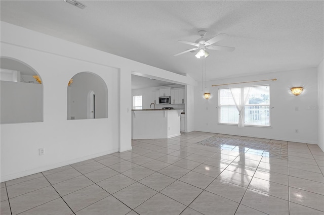 4617 Horseshoe Pick Ln, Valrico, FL 33594 - unfurnished living room with light tile patterned flooring, ceiling fan, a sink, a textured ceiling, and baseboards