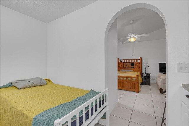 4617 Horseshoe Pick Ln, Valrico, FL 33594 - bedroom with arched walkways, light tile patterned floors, vaulted ceiling, and a ceiling fan