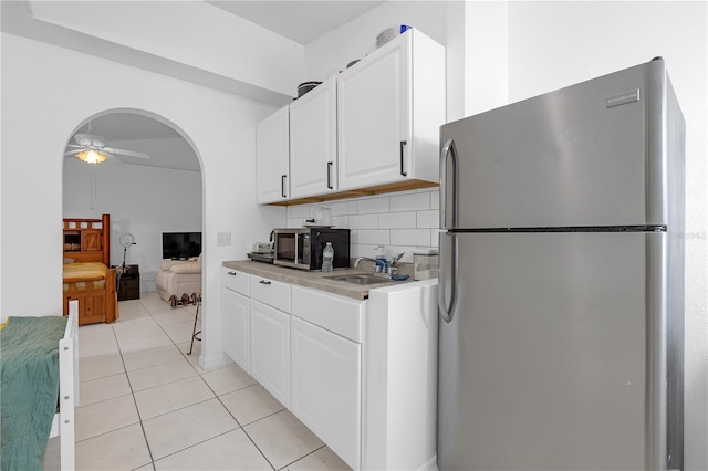 4617 Horseshoe Pick Ln, Valrico, FL 33594 - kitchen with appliances with stainless steel finishes, a ceiling fan, a sink, white cabinets, and light tile patterned floors