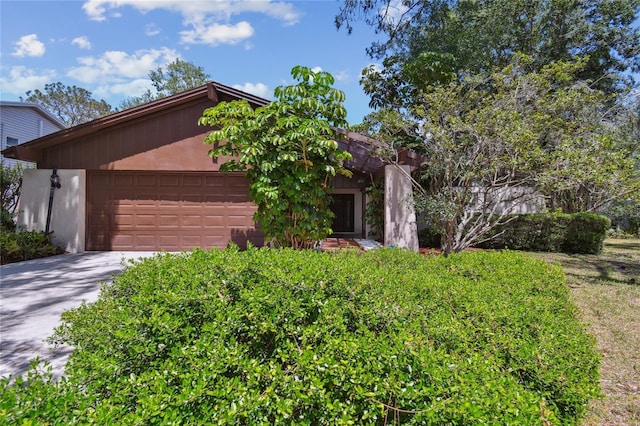 mid-century modern home with concrete driveway and an attached garage