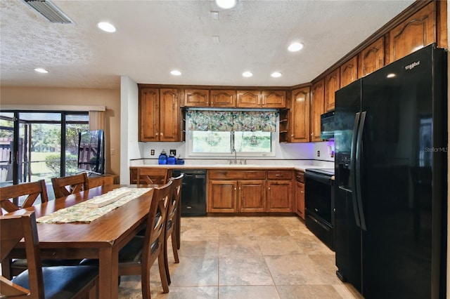 kitchen with brown cabinetry, black appliances, light countertops, and recessed lighting