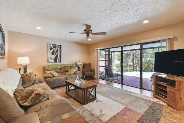 living area featuring light wood-type flooring, recessed lighting, ceiling fan, and a textured ceiling