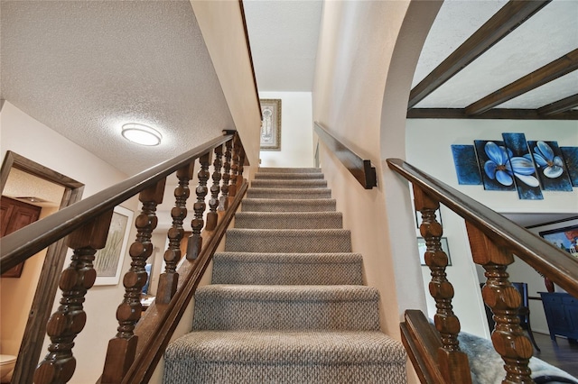 stairs featuring a textured ceiling