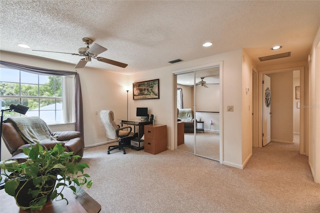 home office featuring a textured ceiling, carpet, a ceiling fan, and visible vents
